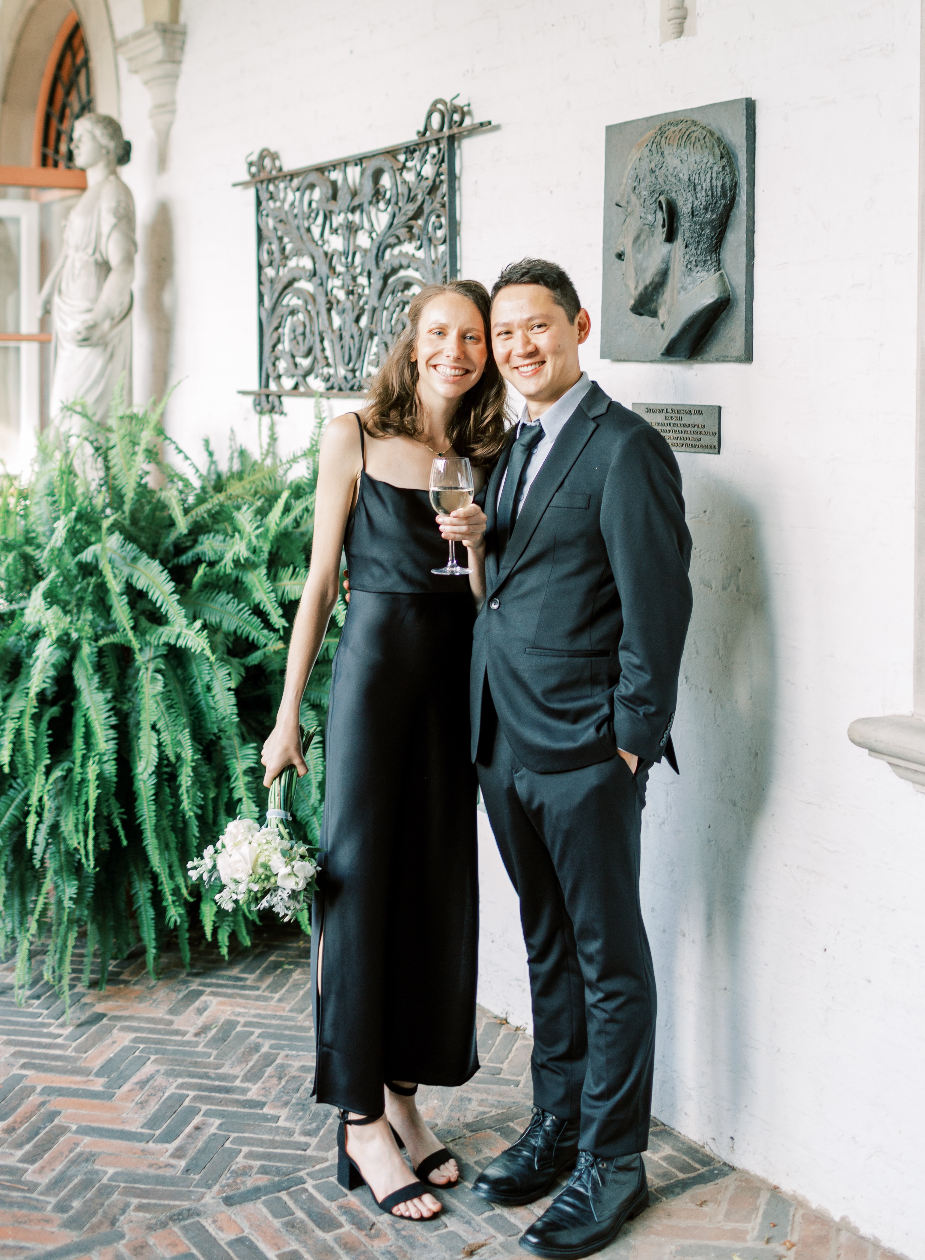 Mary and Matt wearing formal attire in a statue garden.